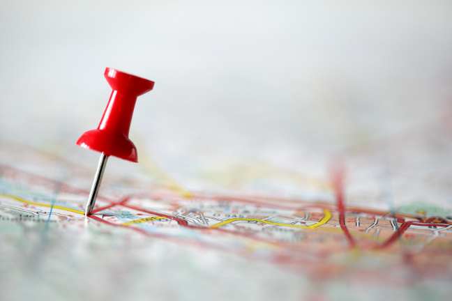 Pushpin on map Red pushpin showing the location of a destination point on a map